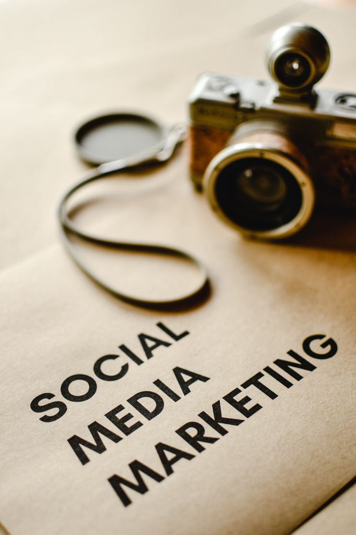 about-04 Close-up of a vintage camera on brown paper labeled with Social Media Marketing.