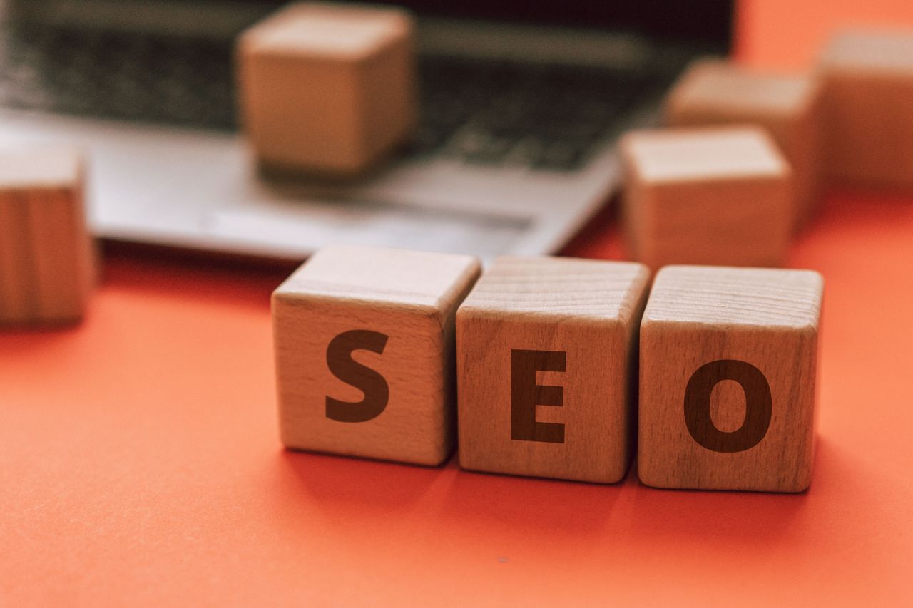 hero-img Wooden blocks spelling SEO on a laptop keyboard convey digital marketing concepts.