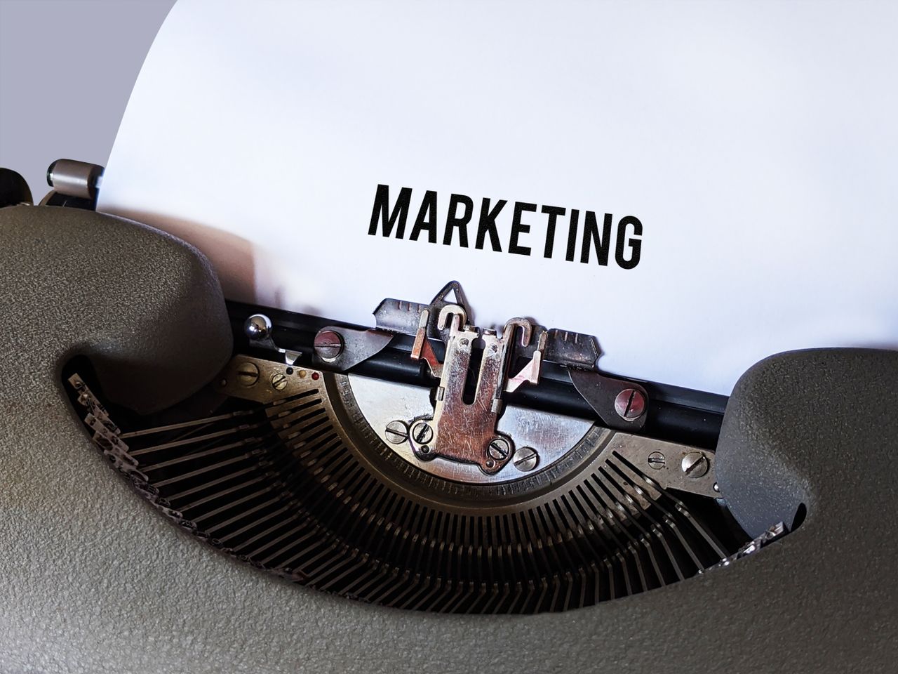 services-01 Close-up of a vintage typewriter with the word Marketing on paper, conveying a retro business theme.